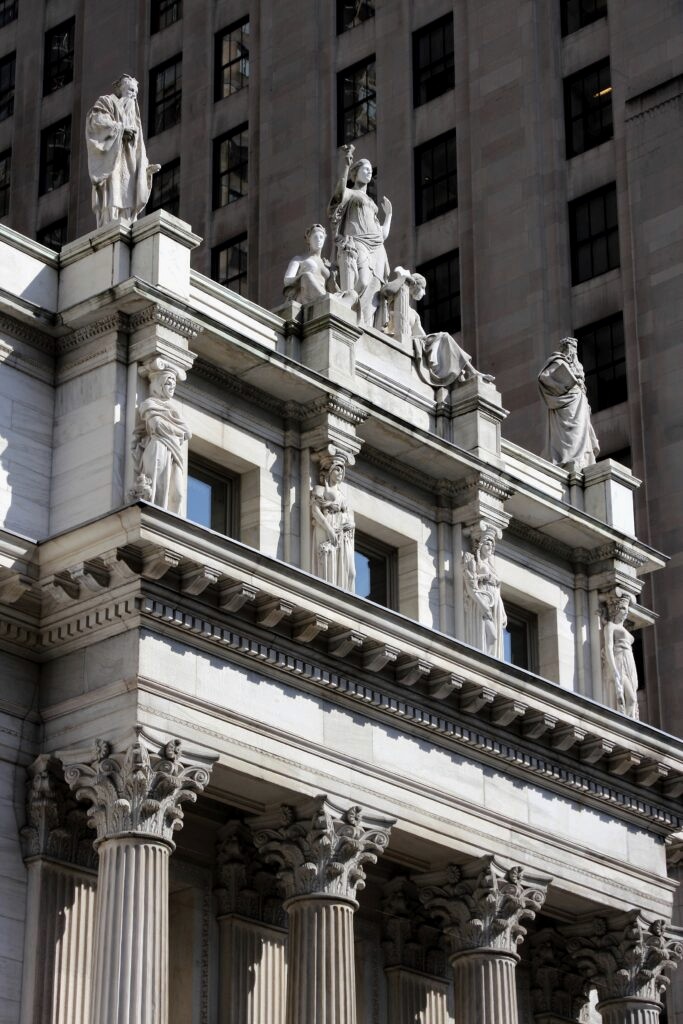 An architectural structure with prominent columns and decorative statues at the entrance.