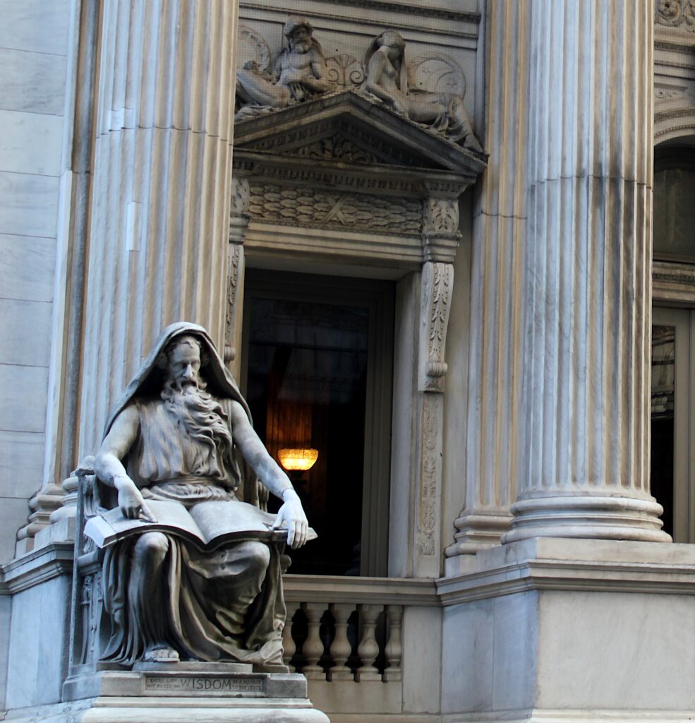 A statue of a man seated on a bench, depicting a moment of contemplation in a public space.