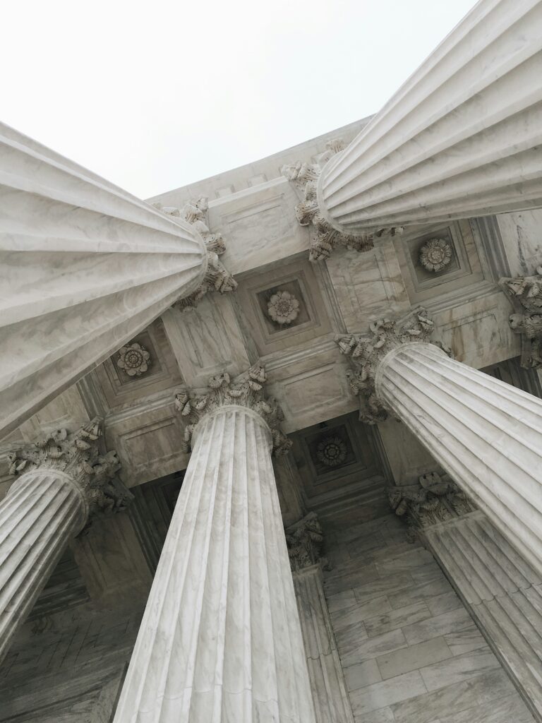 U.S. Supreme Court building with its iconic columns and steps, showcasing classical architecture against a clear blue sky